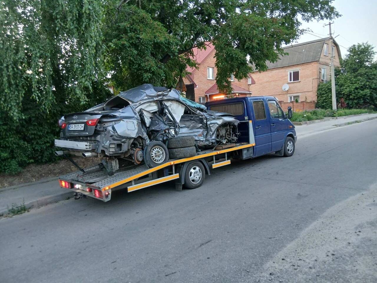 Синій евакуатор перевозить сильно пошкоджений автомобіль після ДТП